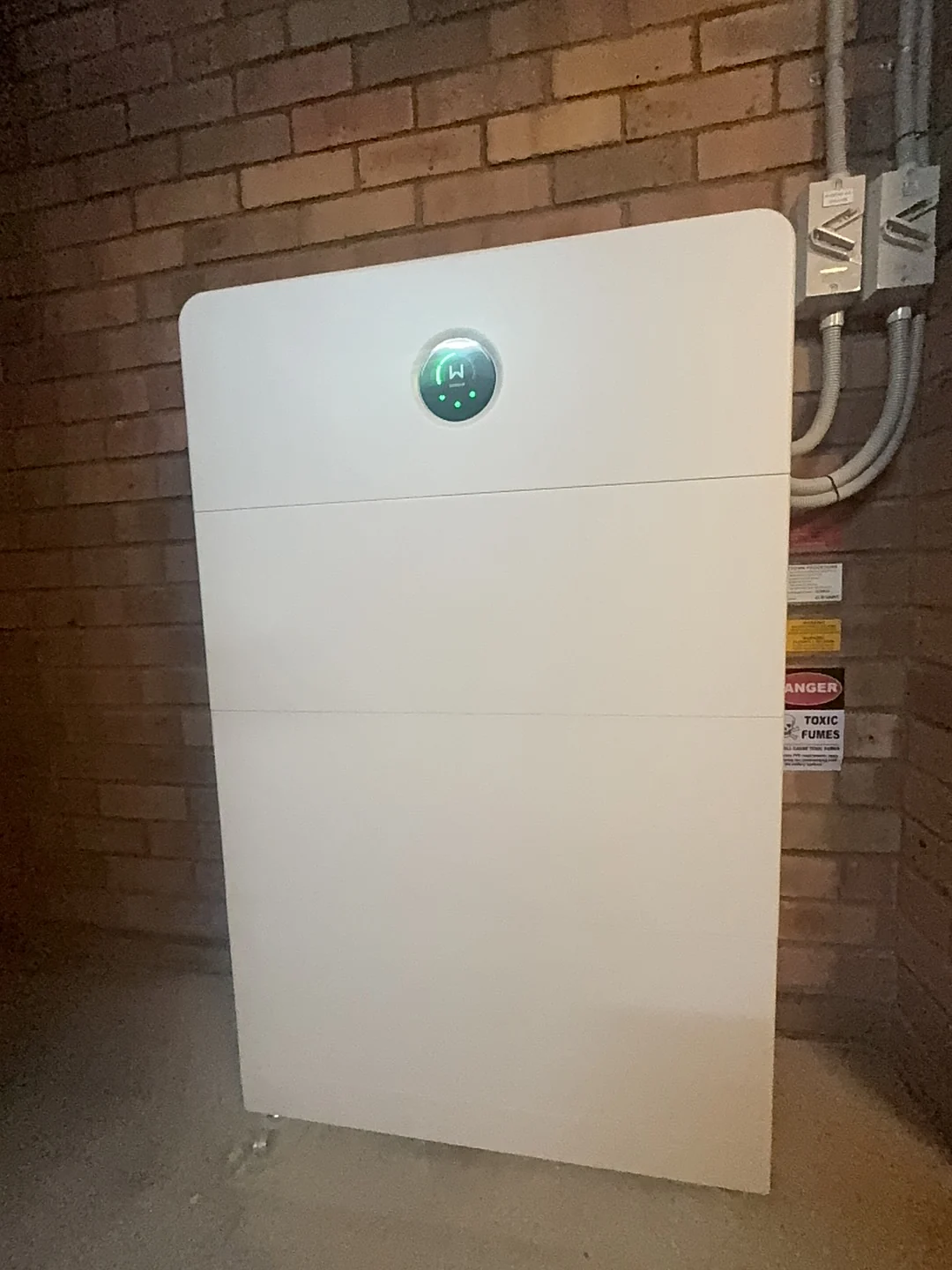 Battery storage beside a brick wall