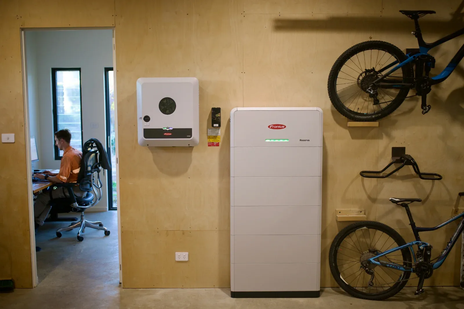 Inverter and battery on the plywood wall, the cabling concealed behind the panelling