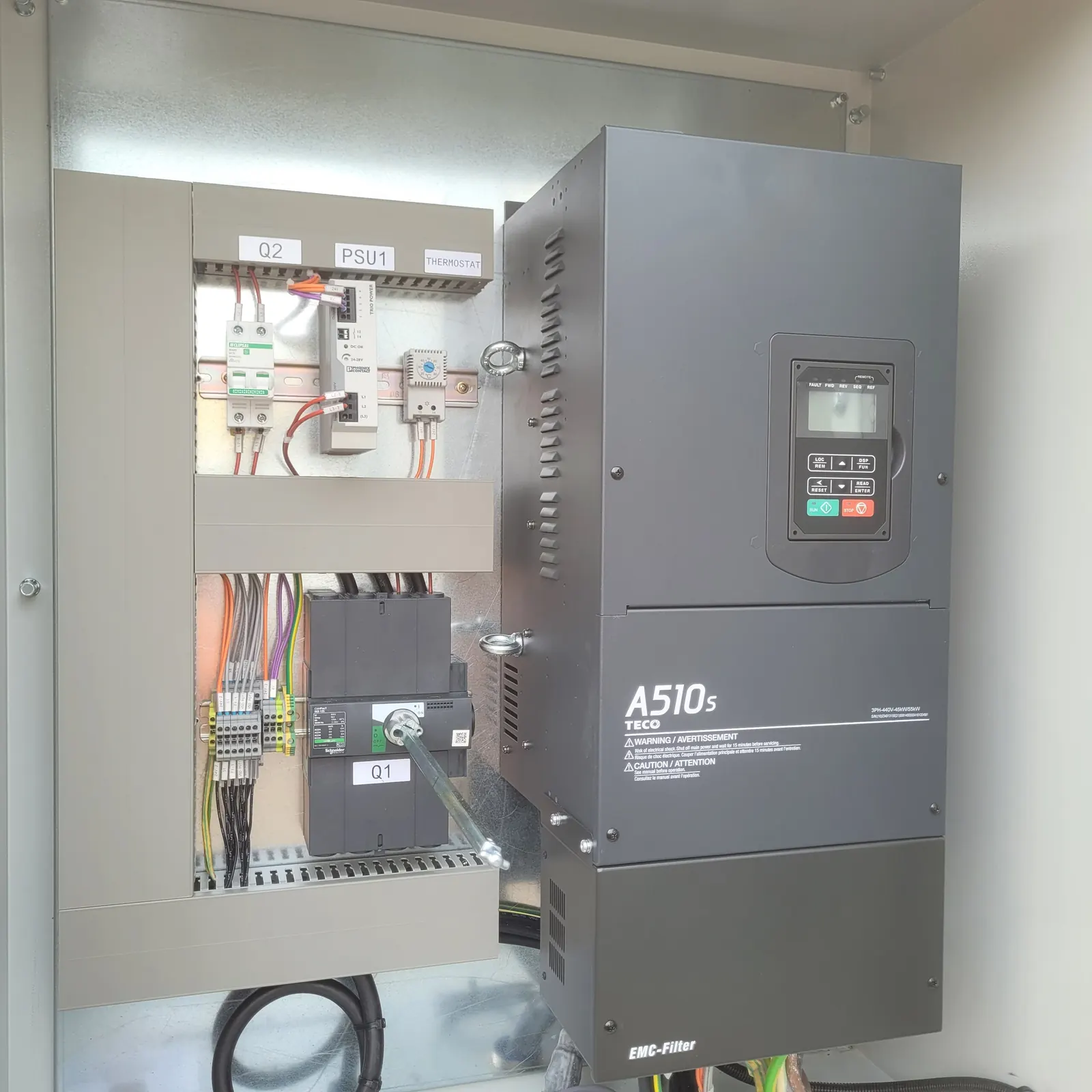 Inside the panel: the variable speed drive beside the circuit breakers, power supply and thermostat