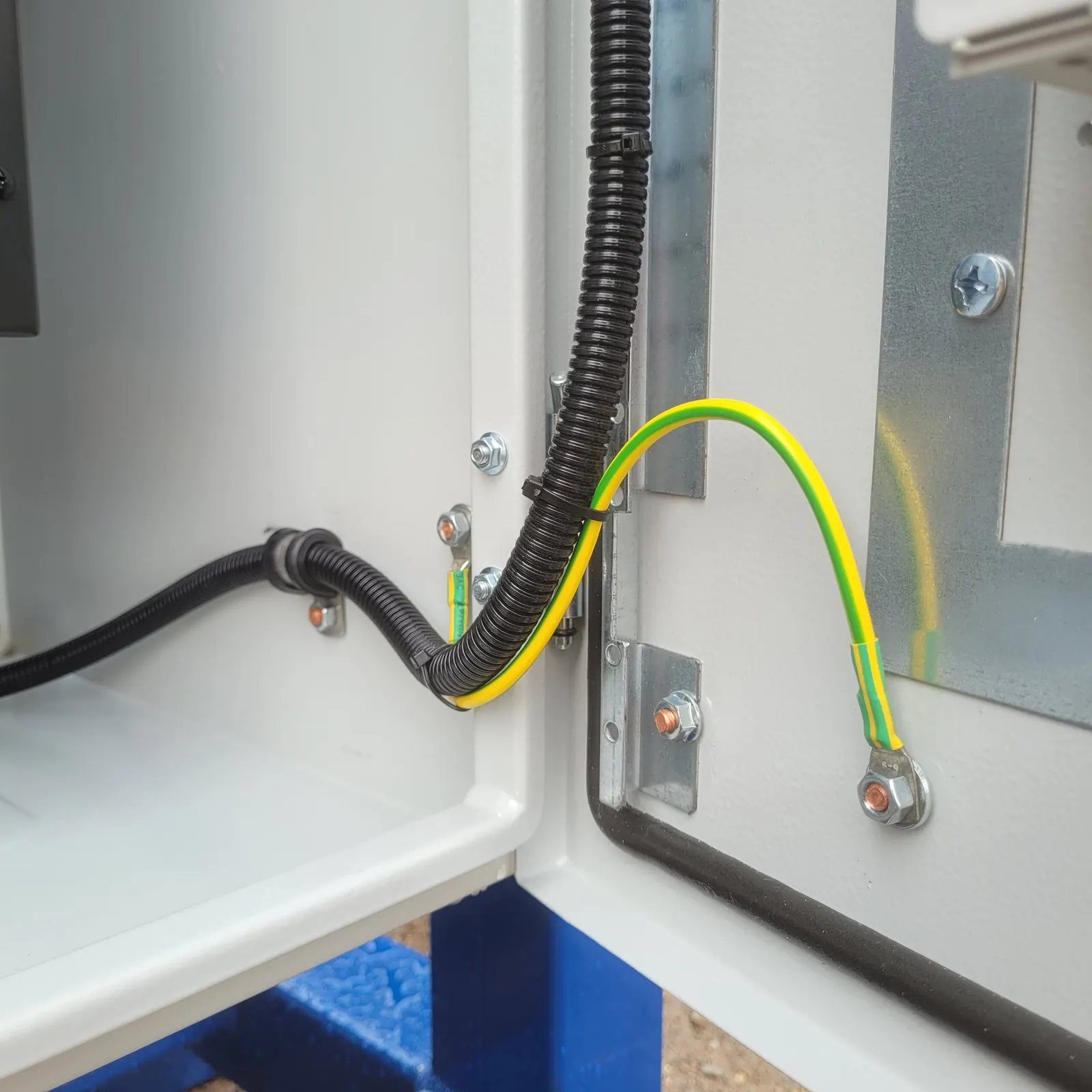 Earth bonding strap and flexible conduit where the wiring crosses to the panel door