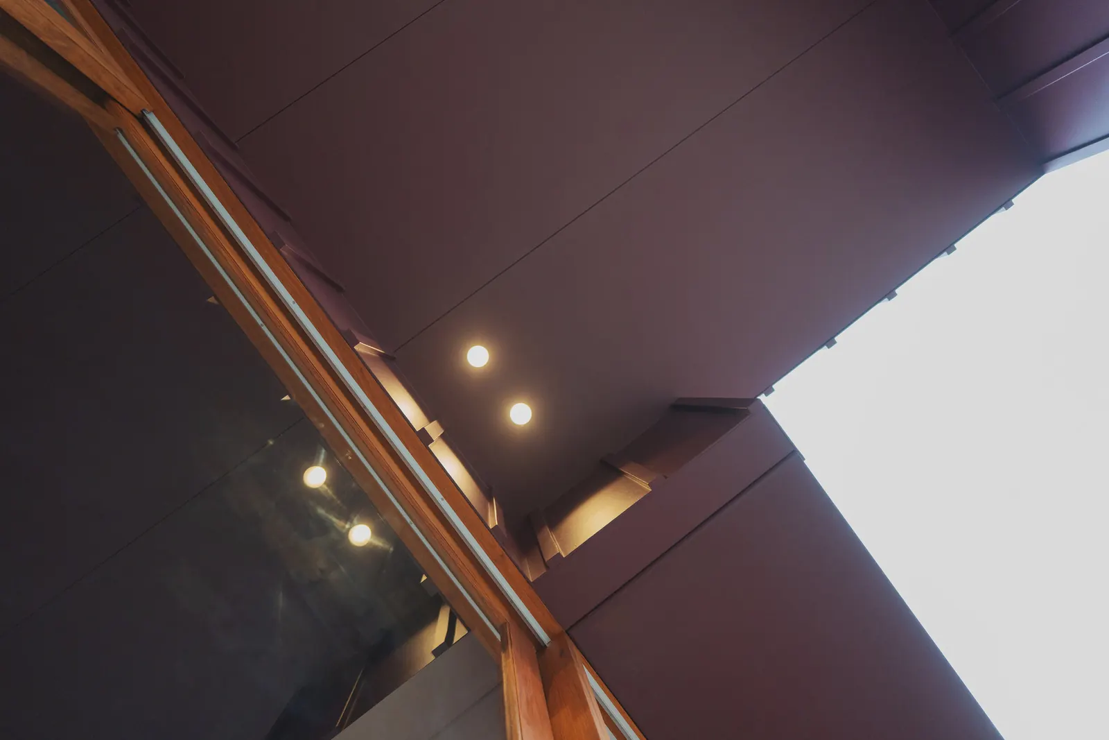 Downlights in the angled ceiling beside the glazing