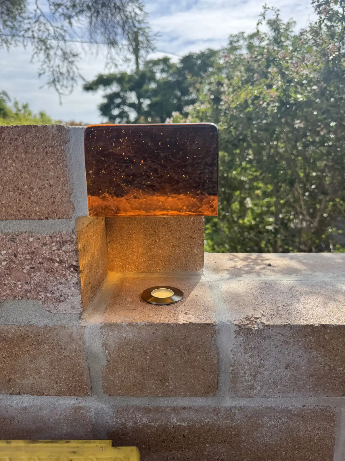 The feature light by day, with a small round light set into the brick below the amber glass block