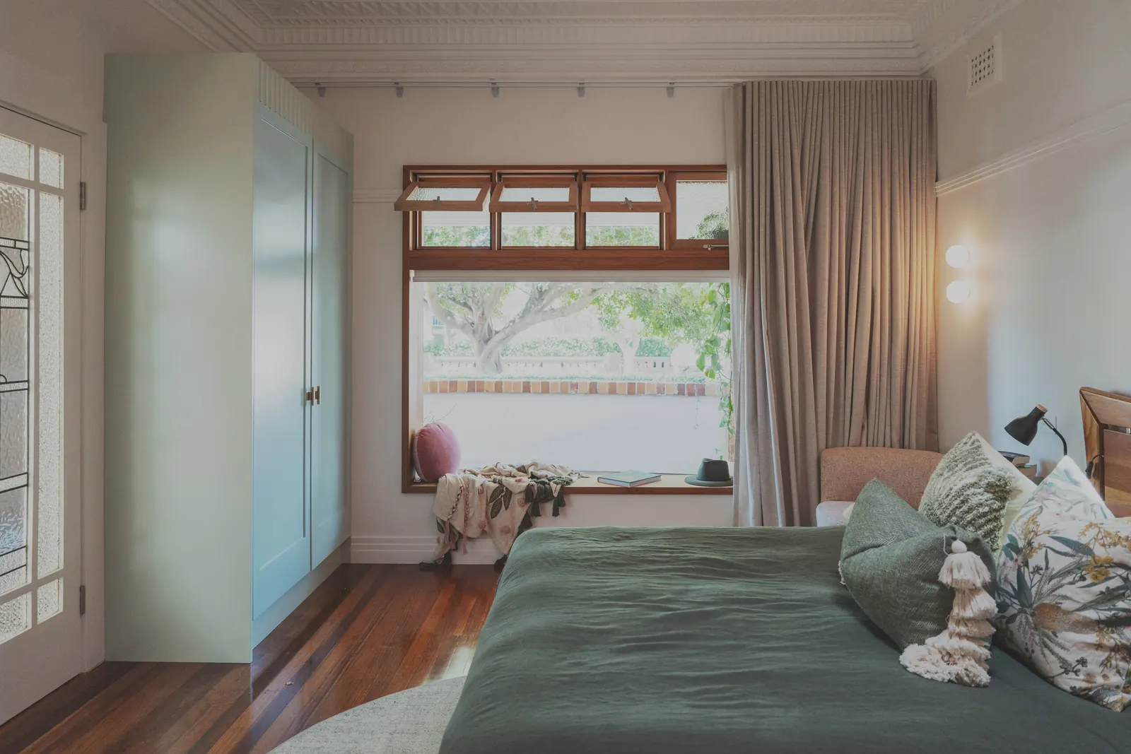 A bedroom with built-in wardrobe and wall lights