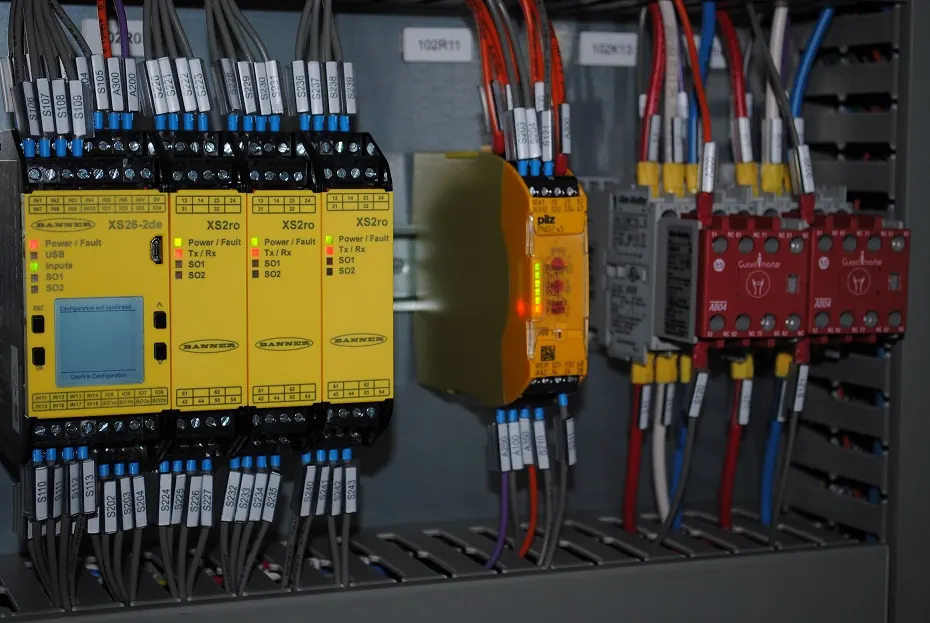 Safety controller and relay modules wired in a control panel